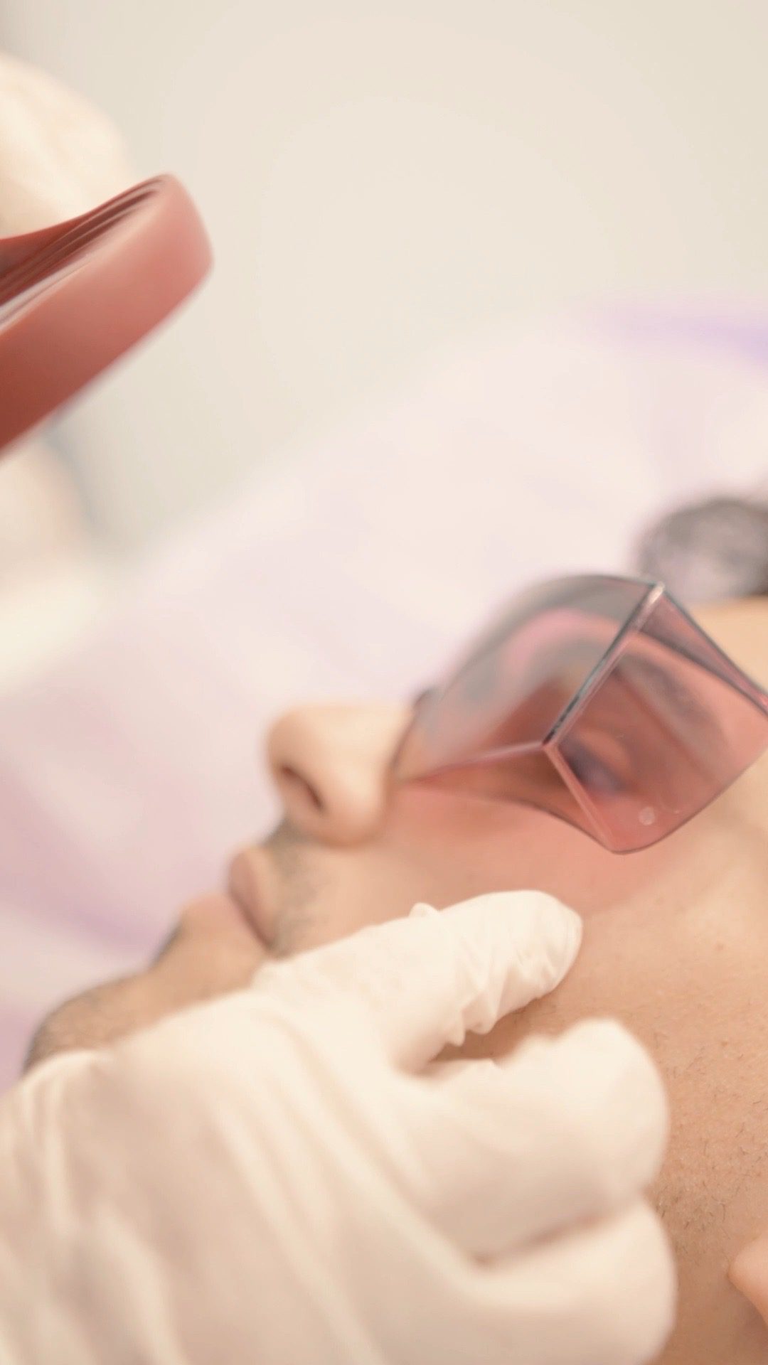 Manipolo laser sul viso di un uomo con gli occhiali protettivi